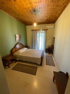 sypialnia z dużym łóżkiem i oknem w obiekcie Petros Studios w mieście Moraitika