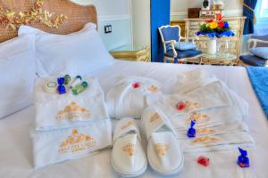 - un ensemble de serviettes et de chaussures sur un lit dans l'établissement ABA LUXURY B E B Nice, à Nice