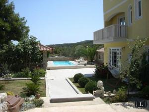 une maison avec une piscine en face de celle-ci dans l'établissement Apartments Villa Lora, à Kraj