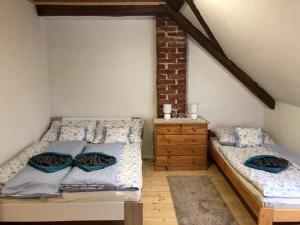 1 dormitorio con 2 camas y tocador de madera en Schwarzenberský panský dvůr, en Čimelice