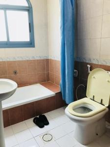 een badkamer met toilet, bad en wastafel bij PAN Hotel Apartments in Sharjah +6 foto's
