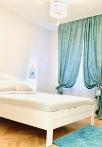 a bedroom with two beds and blue curtains at Middle of The Boulevard in Alba Iulia