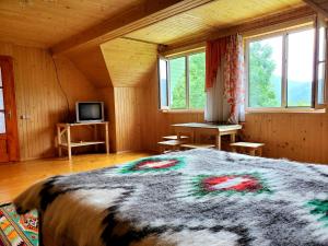 a bedroom with a large bed in a room with windows at Садиба Кичера in Petrashani