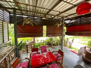 una mesa y sillas en una terraza con mesa y sillas rojas en Huen Vasana Chiang Dao en Chiang Dao