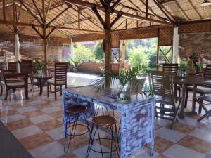 a restaurant with tables and chairs and a stone counter at Pondok Bamboo Sendangsari in Wonosobo