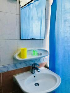 een badkamer met een wastafel en een spiegel bij PAN Hotel Apartments in Sharjah