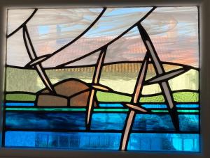 a stained glass window with a view of the ocean at The Crail Maltings in Crail