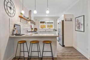 a kitchen with two bar stools at a counter at White on Wright Clare in Clare