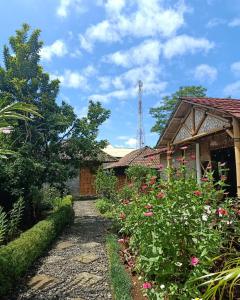 um caminho de jardim que leva a uma casa com flores em Pondok Bamboo Sendangsari em Wonosobo