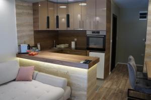 a kitchen with a counter and a couch in a room at Lux Apartman Bogosavljevic in Soko Banja