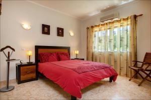 1 dormitorio con cama roja y ventana en VILLA DOMIPAJO, en Carvoeiro