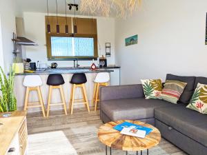 a living room with a couch and a kitchen at Casa Cocoon, Sun&Freedom, 8 mn from beaches, internet fiber in Lajares