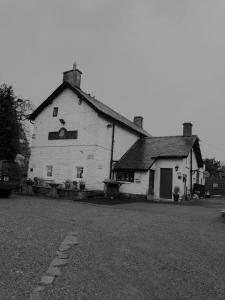 
a white house with a black and white house at The Royal Oak Inn, in Wetton
