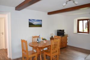 a dining room with a wooden table and chairs at Ferienwohnung-Max-22 in Müglitztal