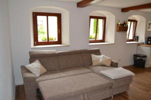 a living room with a couch and two windows at Ferienwohnung-Max-22 in Müglitztal