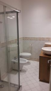 a bathroom with two toilets and a glass shower at La casa di Pier in Olbia