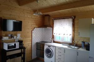 a kitchen with a washing machine and a microwave at Los Tréboles in Bocigas