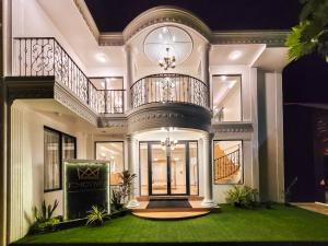 una grande casa con balcone e scala di KingsWay Thoddoo Maldives a Thoddoo
