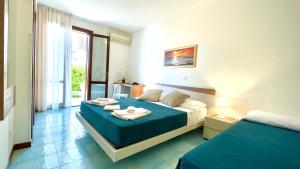 ein Hotelzimmer mit 2 Betten und einem Fenster in der Unterkunft Hotel Sikania in San Vito lo Capo