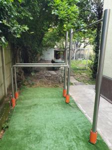 un patio verde con postes de naranja y un columpio en Tranquillità e cordialità a 30 minuti da MIlano, en Busto Arsizio