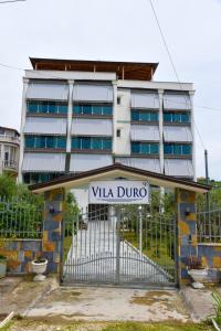 a gate in front of a building with a sign at Vila Duro in Golem