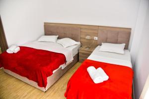 una camera con due letti e una coperta rossa di Vila Duro a Golem
