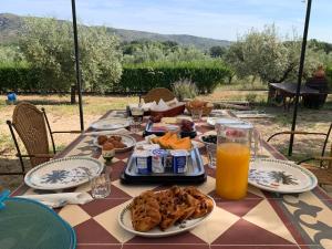 a table topped with plates of food and orange juice at Finca La Higuera - Boutique B&B in Ontinyent
