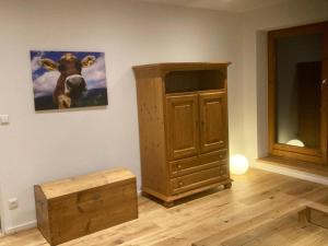 a room with a wooden cabinet and a painting on the wall at Ferienwohnung Allgäuflair in Missen-Wilhams