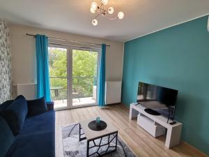 a living room with a blue couch and a tv at Apartament NaGrobli in Wrocław