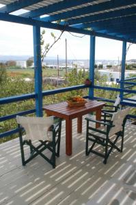 a wooden table and chairs on a deck with a view at Miltiadis Apartments in Ambelas