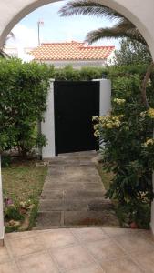 Un arco que conduce a una puerta negra en una casa en FONOLL MARÍ, en Cala en Forcat