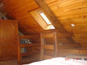 Schlafzimmer mit Holzdecke und Fenster in der Unterkunft Gite La Maison du Pêcheur in Ploemel