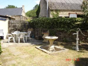 普羅梅爾的住宿－Gite La Maison du Pêcheur，一个带桌椅的花园和一个喷泉