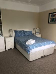sypialnia z łóżkiem z niebieską pościelą i niebieskimi poduszkami w obiekcie Kew Gardens & National Archives w mieście Richmond upon Thames