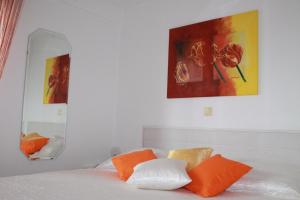 1 dormitorio con 1 cama con almohadas de color naranja y blanco en Ferienwohnung in Sabunike mit Terrasse, Klimaanlage, W-LAN (231-2), en Privlaka