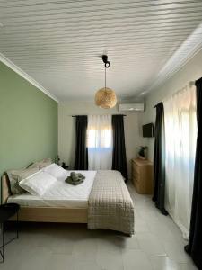 1 dormitorio con cama y lámpara de araña en Agrothi en Marathopoli
