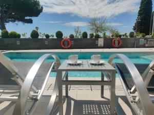 a table and chairs next to a swimming pool at Canyelles Platja in Roses