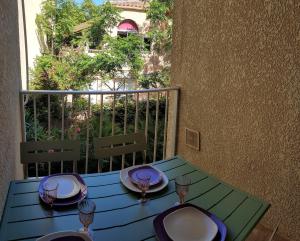 a table with plates and wine glasses on a balcony at Duplex les pieds dans l'eau in Albitreccia