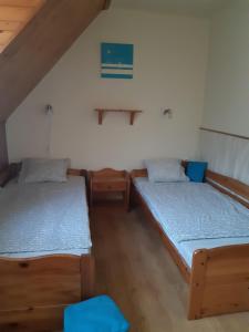 2 Einzelbetten in einem Zimmer mit Holzböden in der Unterkunft Pákász Nyaralóház in Tiszafüred