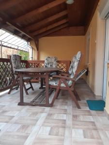 Pákász Nyaralóház في تيسزافوريد: طاولة خشبية وكرسيين على شرفة
