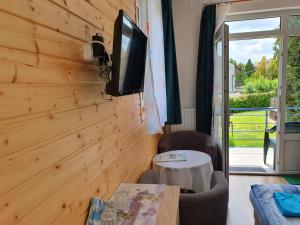 sala de estar con TV en una pared de madera en Laguna Apartmanház, en Hévíz