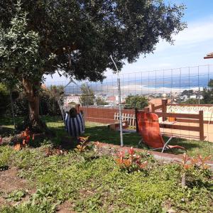 un patio con un árbol y sillas y una valla en Casa Andrea en Valdoviño