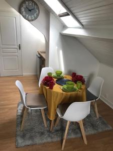 comedor con mesa con sillas y reloj en Appartement T2 meublé, en Saint-Quentin