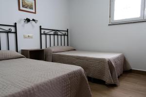 a bedroom with two beds and a window at Casa Area da Vila in Camariñas