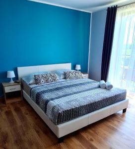 a bedroom with blue walls and a large bed at Moris Pokoje Gościnne in Łeba