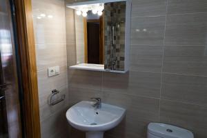a bathroom with a sink and a toilet and a mirror at Casa Area da Vila in Camariñas