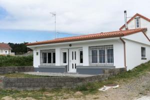 a small white house with a red roof at Casa Area da Vila in Camariñas