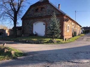 un antiguo edificio de ladrillo con un gran garaje blanco en Schwarzenberský panský dvůr, en Čimelice