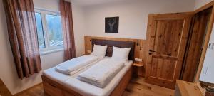 a bedroom with a bed with white sheets and a window at Ferienwohnung Turracherhöhe in Turracher Hohe