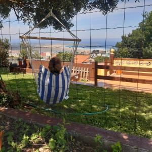 a person sitting in a hammock in a yard at Casa Andrea in Valdoviño +30 photos